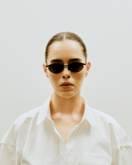 Alma eyewear displayed on a matt balck titanium surface, highlighting handcrafted Japanese quality