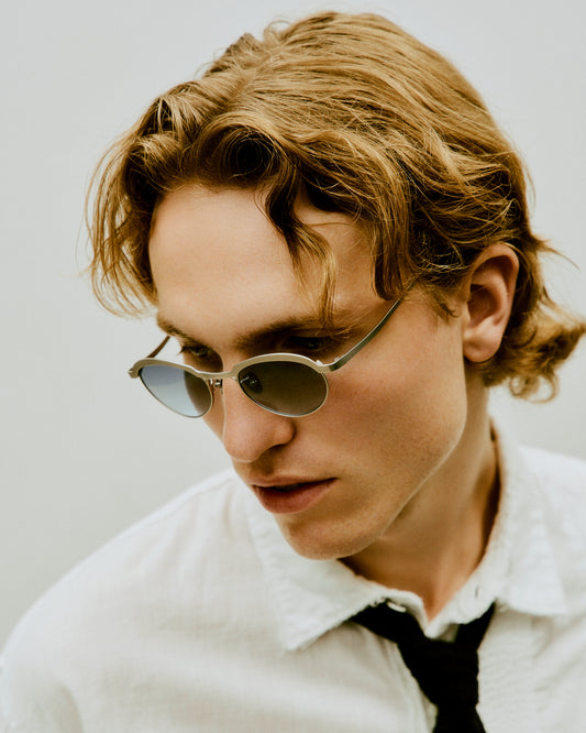 Theodor round glasses resting on a textured background, made from premium titanium